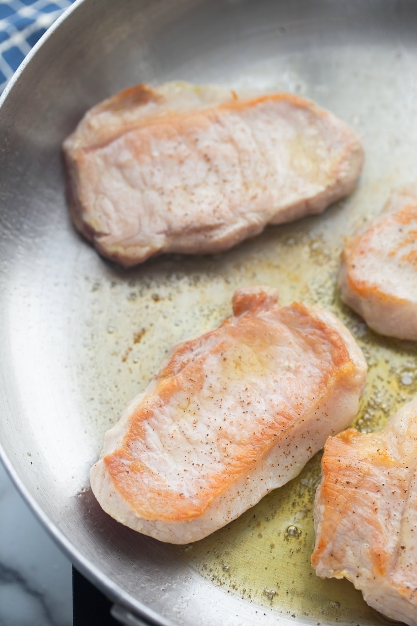 Boneless pork chops with a balsamic fig sauce, highlighting savory shallots and dried figs in the most elegant way. boneless pork chops in a skillet