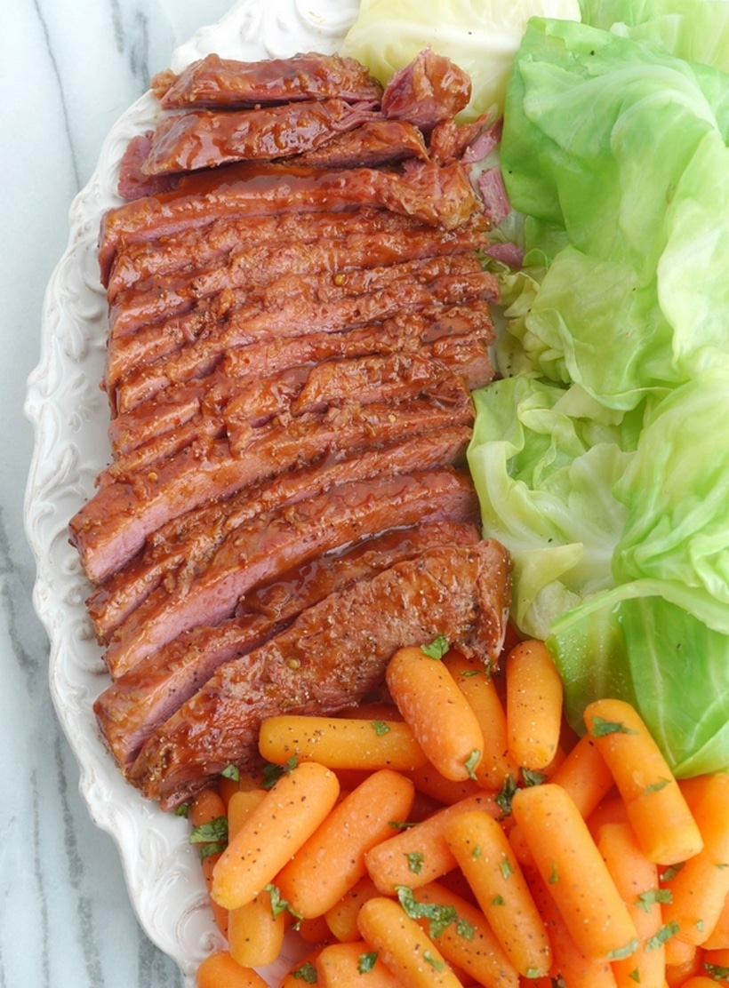 Whiskey-Glazed Corned Beef with carrots Overhead view of the full platter with whiskey-glazed corned beef, roasted carrots, and cabbage, highlighting the rich colors and textures.