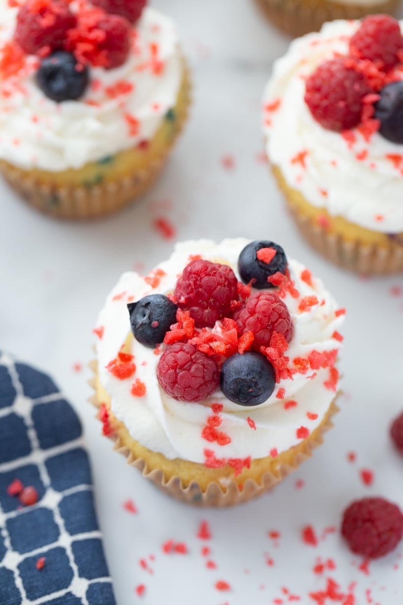 Pop Rocks cupcake close-up with candy and fruit toppings. Firework cupcake topped with whipped cream, raspberries, blueberries, and Pop Rocks.