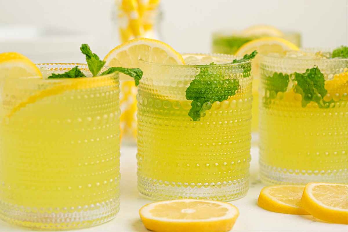 simple lemon and limoncello cocktail : lemonade limoncello cocktail with crushed ice, mint sprig, and a lemon wedge