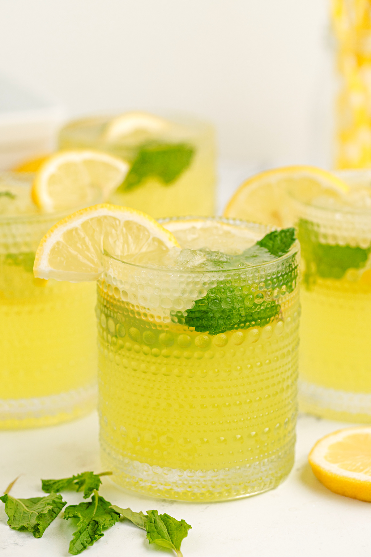 limoncello lemonade cocktail limoncello lemonade with mint and lemon slices over crushed ice in textured glasses
