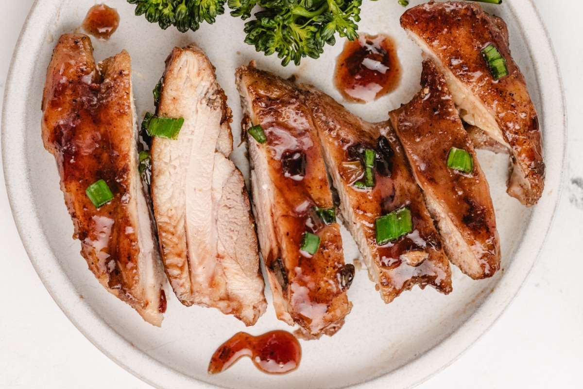sliced Saucy Plum Chicken Close-up shot of sliced saucy plum chicken, showing the tender texture and deep, glossy coating of the plum sauce.