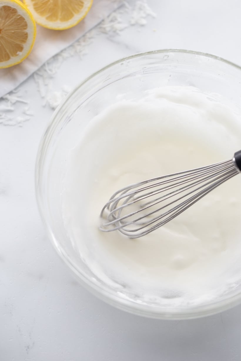 Making glaze in a clear bowl with whisk Whisking glaze in a clear bowl, ready to be drizzled on the baked loaf.