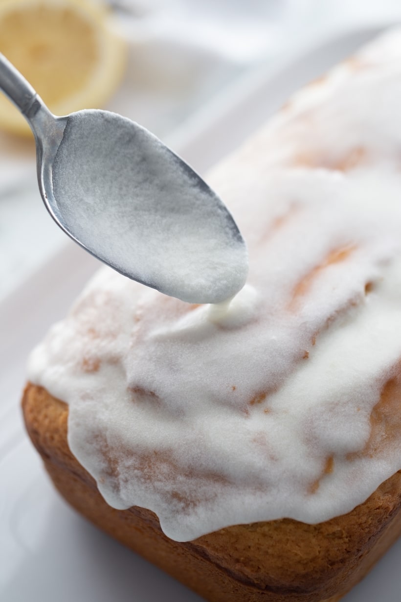 Spoon over baked loaf with glaze Spoon dripping glaze over the freshly baked loaf, adding a sweet finish.