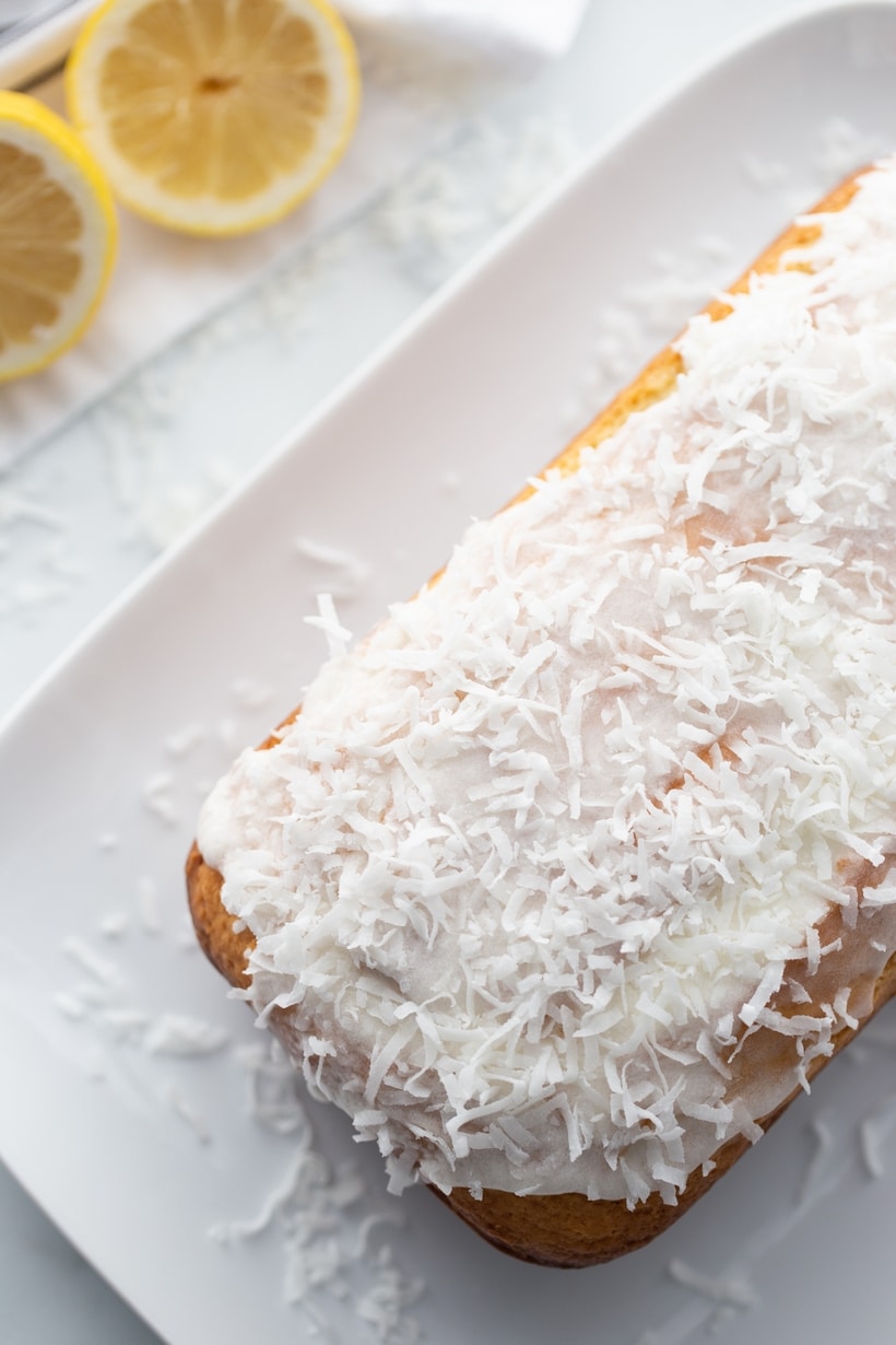 Overhead of full loaf with glaze and coconut on top Overhead shot of the full coconut-lemon loaf topped with glaze and coconut.