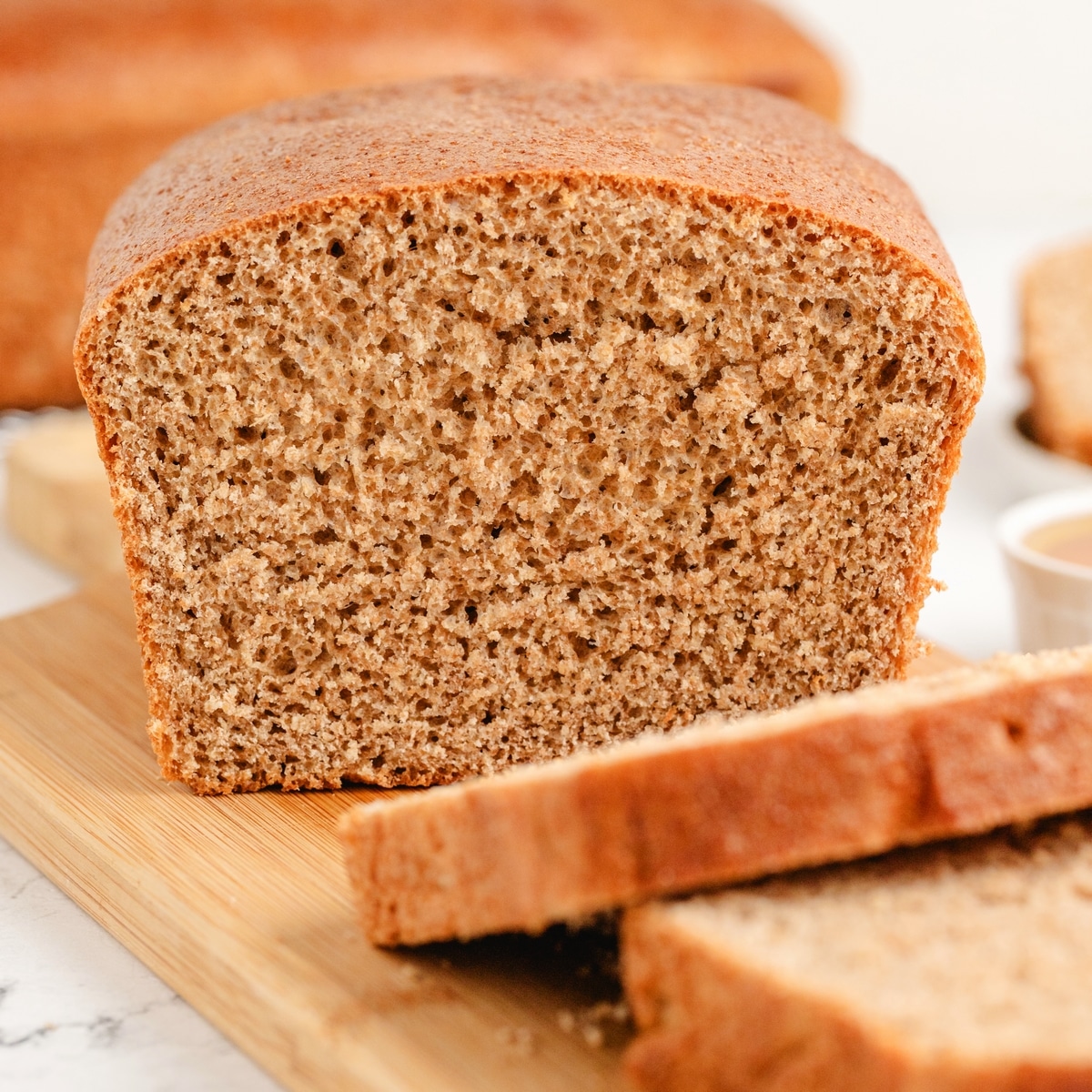 Sliced honey whole wheat sandwich bread. Sliced loaf of honey whole wheat sandwich bread on a cutting board.