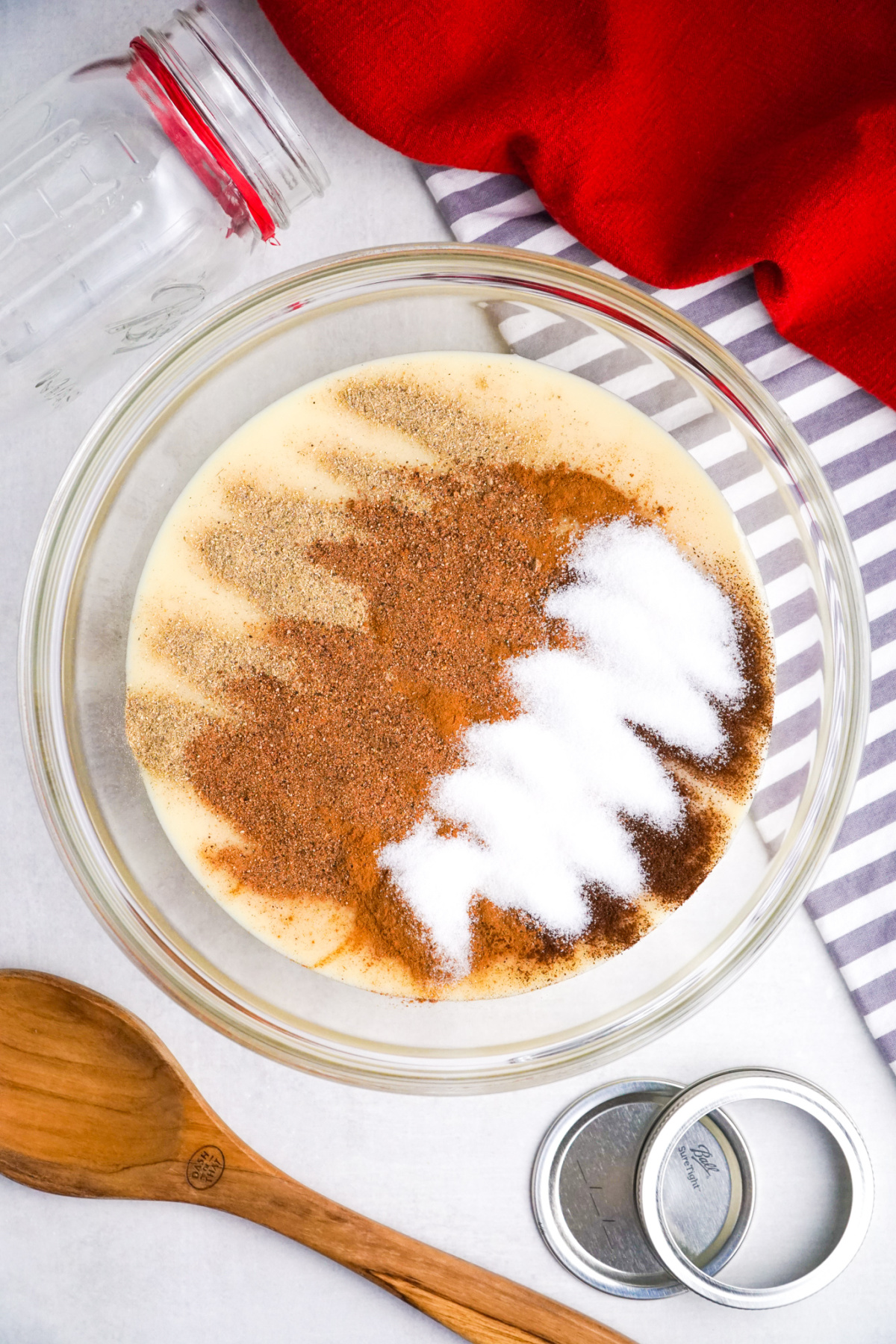  Ground spices and sugar resting on sweetened condensed milk before mixing