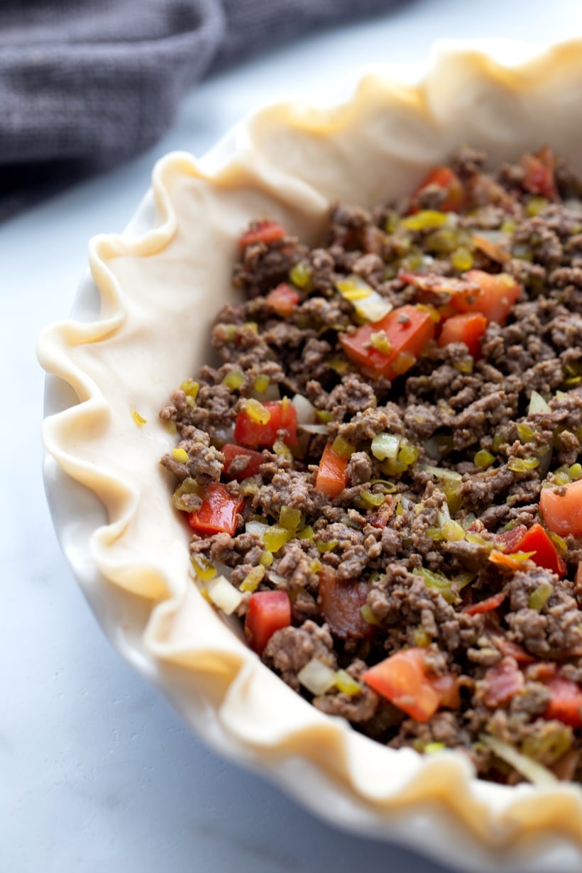 A Cheeseburger Quiche that tastes just like the hamburger you've been craving. Packed with ground beef protein and bacon, this quiche is the best! cheeseburger pie before baking