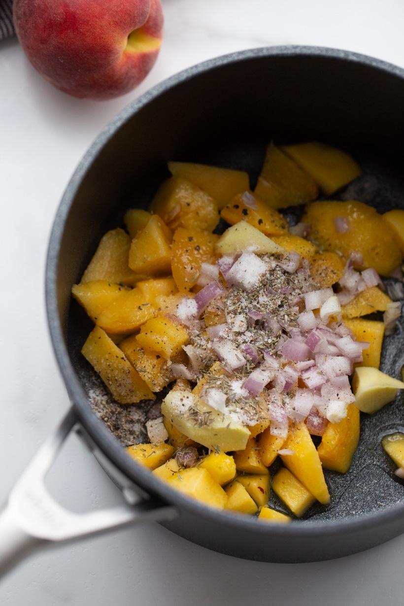 Ingredients for peach chutney before cooking Saucepan filled with peaches, ginger, and shallots before cooking the chutney