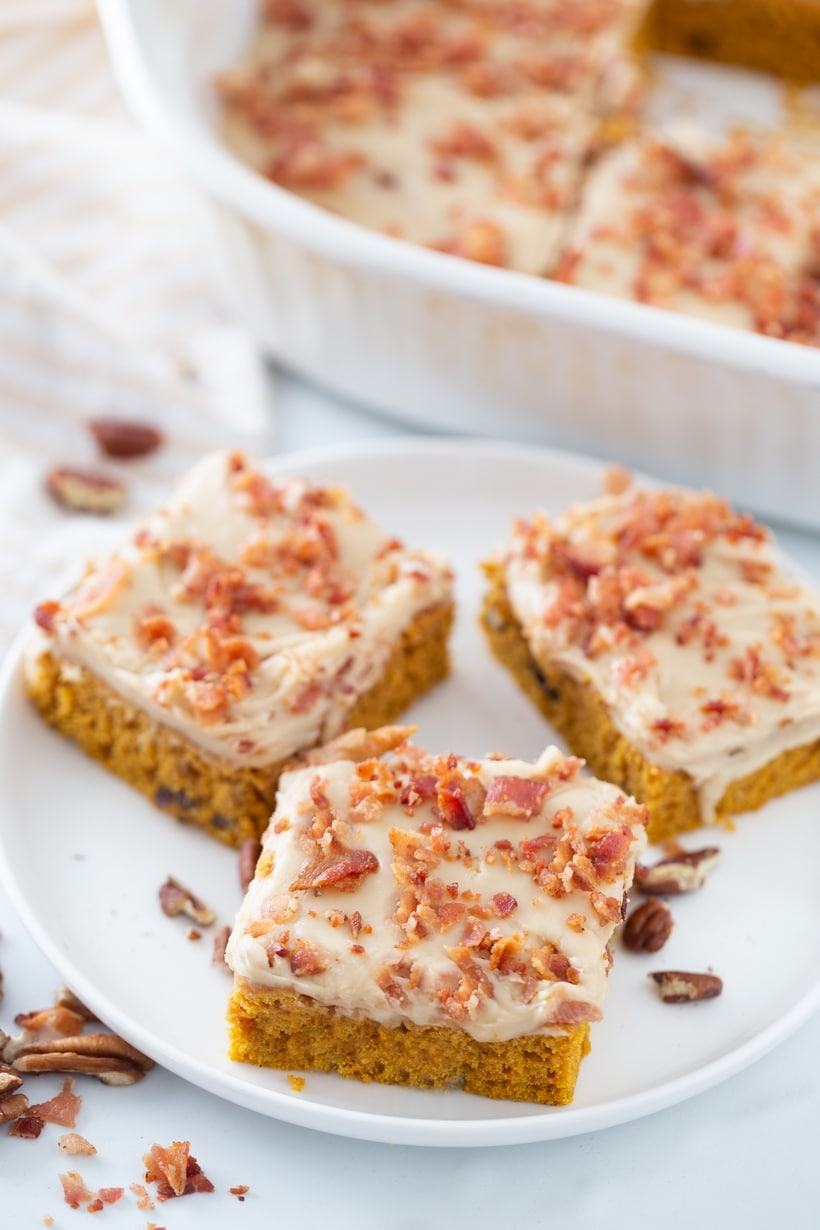 These Pumpkin Caramel Bars with Bacon are the salty-sweet dessert combination you have been craving. With bacon sprinkled on top and drippings in the pumpkin layer you are in for a treat. Pumpkin bars on a plate.
