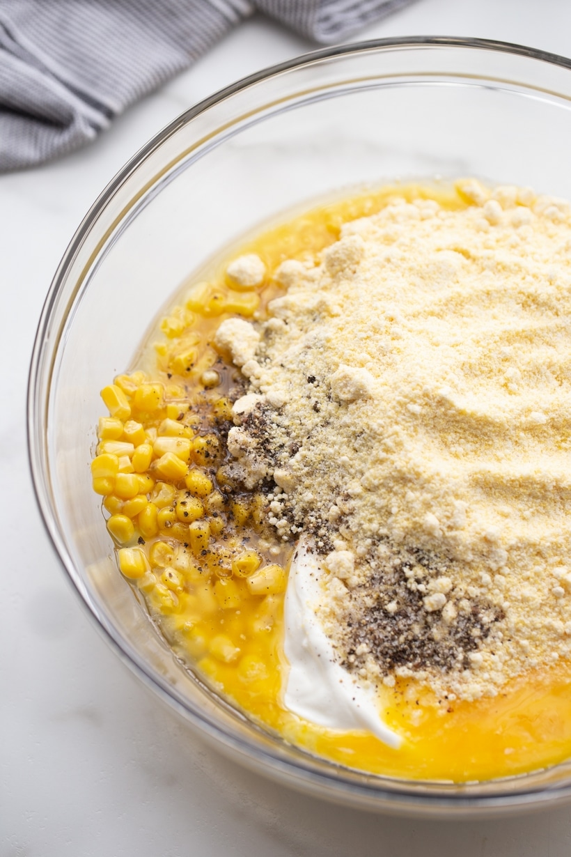 Corn Pudding ingredients in a bowl Overhead view of a mixing bowl filled with corn pudding ingredients before being stirred together.