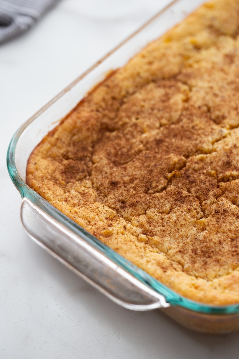Baked corn pudding with cinnamon Corn pudding in a casserole dish after baking, lightly sprinkled with ground cinnamon on top.