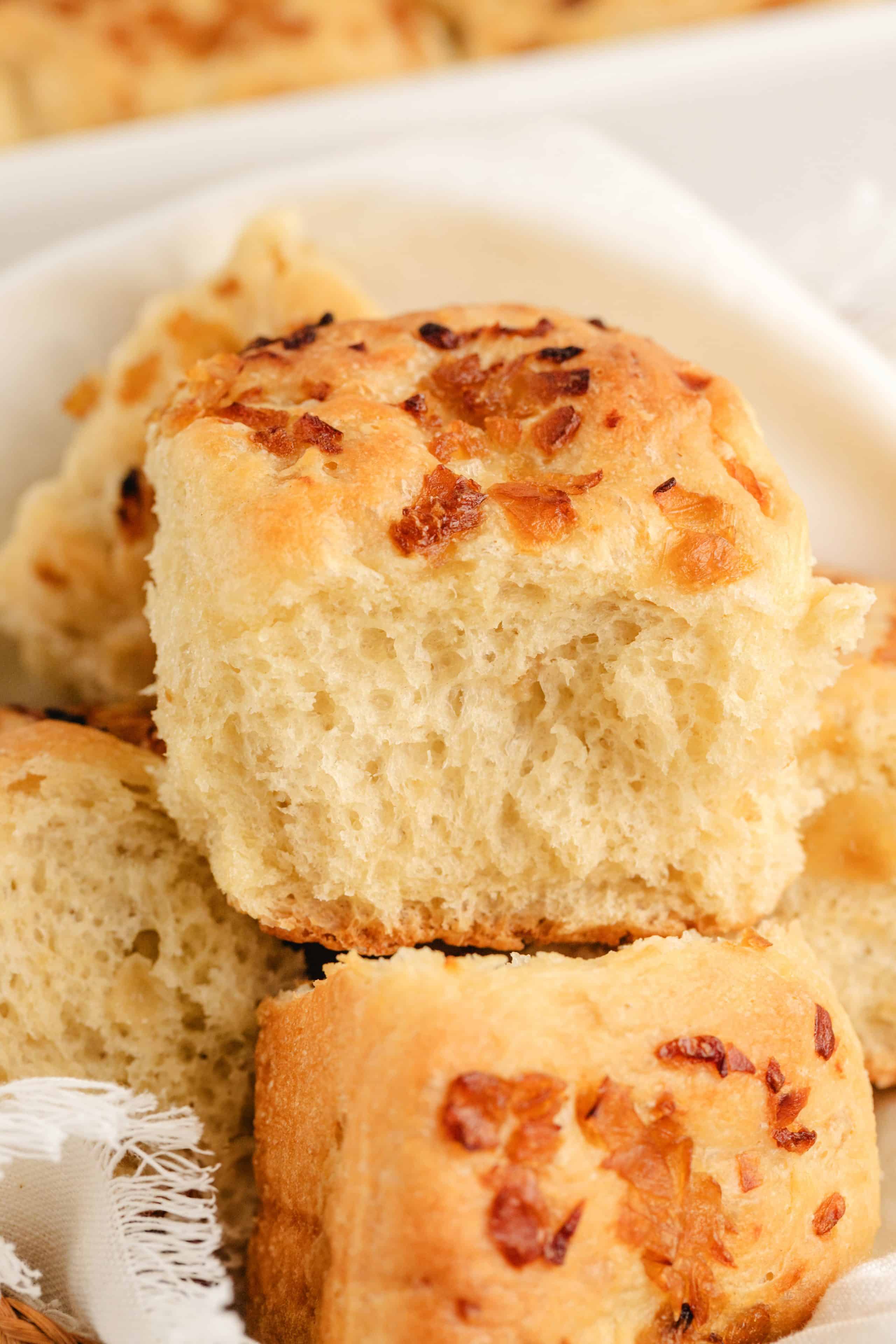 A close-up of onion rolls stacked together, highlighting their airy texture and rich onion flavor.