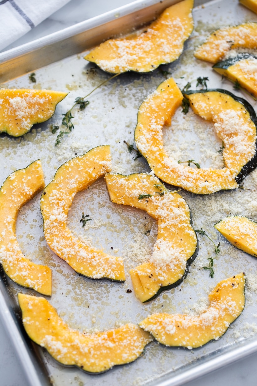 acorn squash slices topped with Parmesan and thyme before roasting