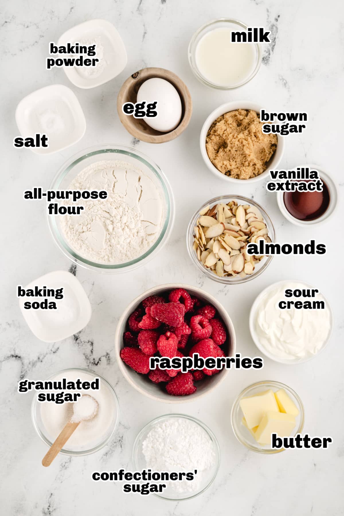 Raspberry Almond Coffee Cake ingredients Overhead shot of all the ingredients for the raspberry almond coffee cake, including flour, sugar, eggs, butter, sour cream, raspberries, and almonds.
