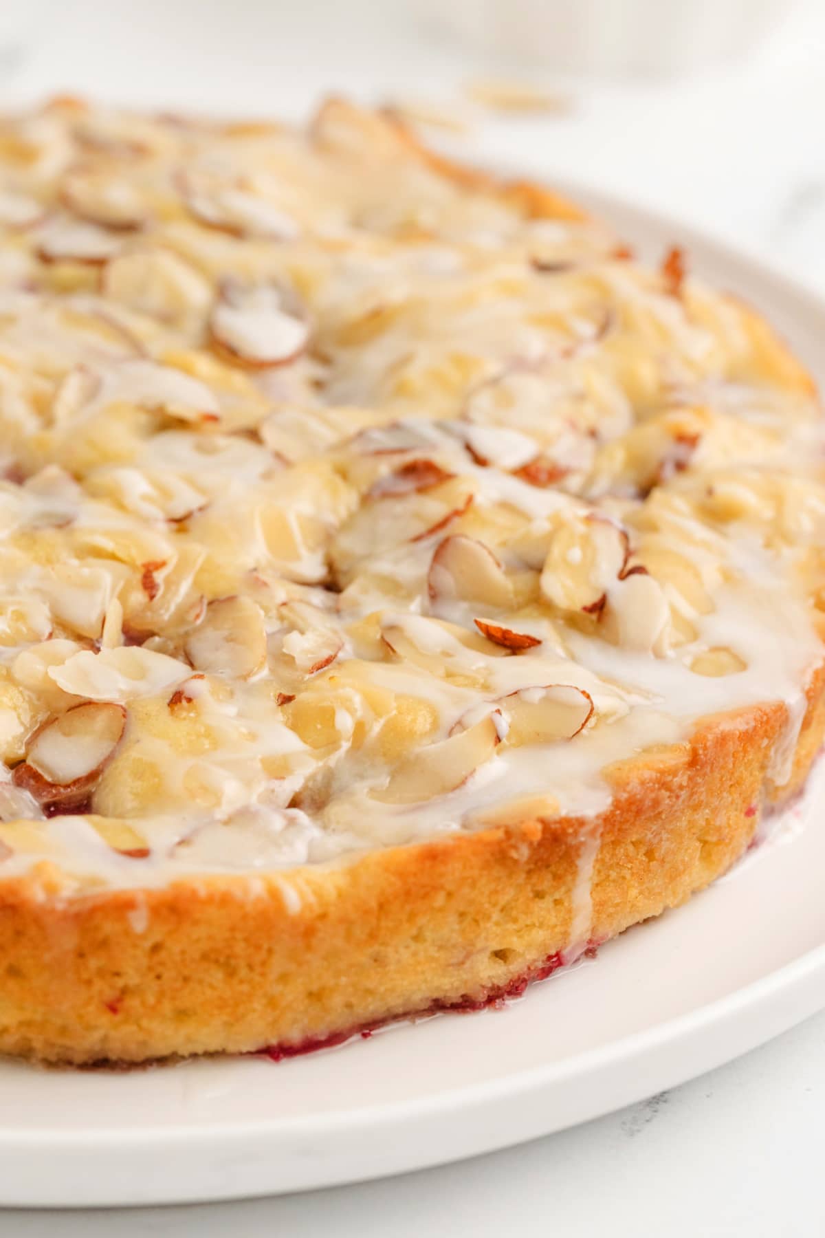 A whole Raspberry Almond Coffee Cake Full raspberry almond coffee cake intact in the pan, showing the golden-brown top with sliced almonds and pockets of raspberries.