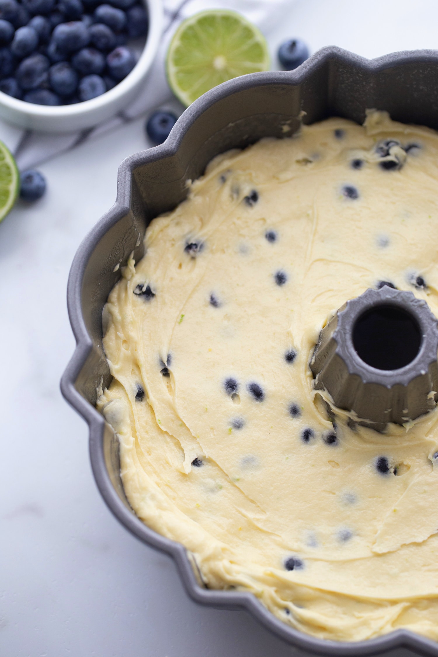 ready to bake Blueberry-Lime Pound Cake Overhead view of smooth batter evenly spread in a floured Bundt pan, ready to bake.