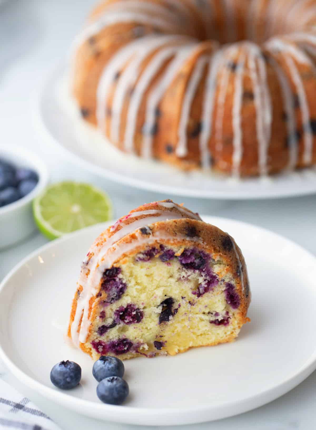 Sliced Blueberry-Lime Pound Cake A close-up of a sliced piece of blueberry-lime pound cake with visible lime glaze and tender crumb.
