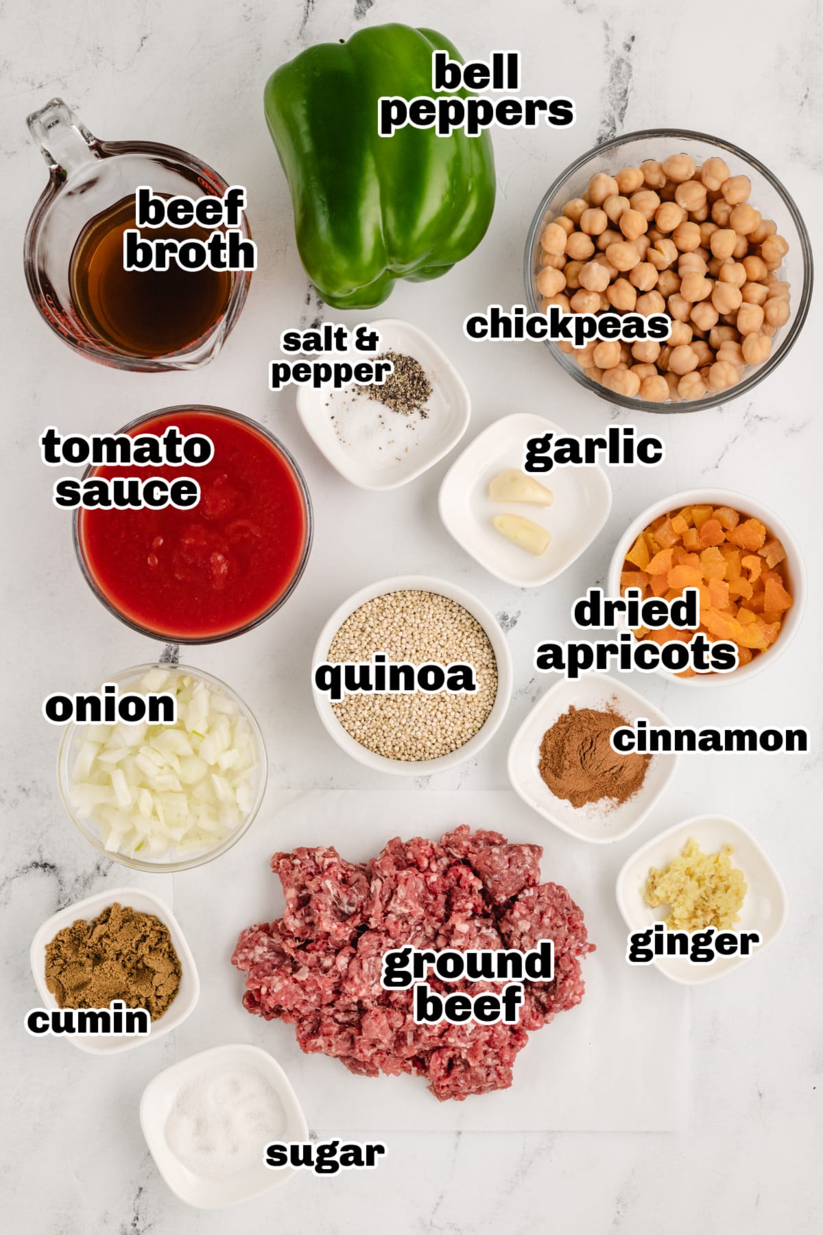 Mediterranean-Style Stuffed Peppers ingredints Ingredient shot with all components laid out, including ground beef, quinoa, bell peppers, chickpeas, tomato sauce, dried apricots, and warm spices.