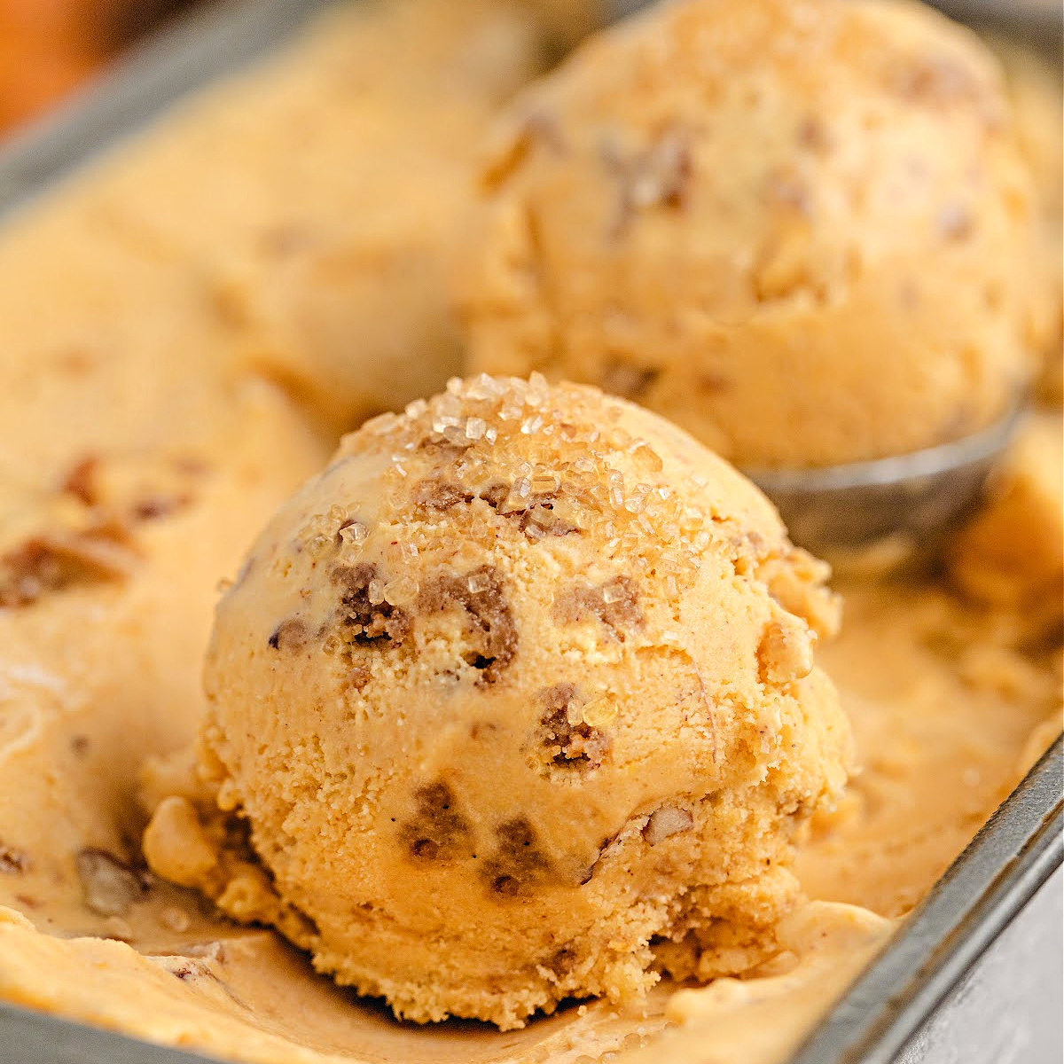 Pumpkin Brown Sugar Crunch Ice Cream by Noble Pig in a metal pan with creamy custard scoops, baked streusel, and turbinado sugar sparkle.