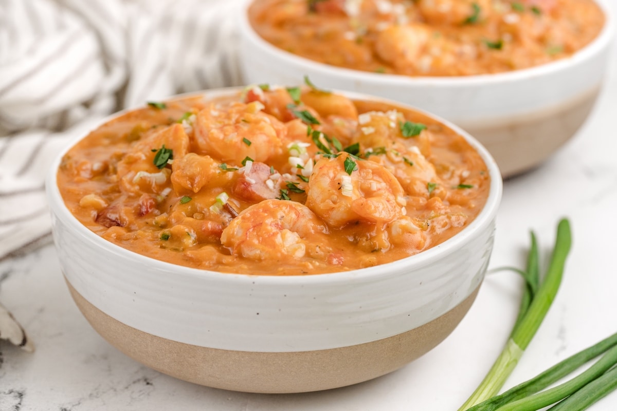 Creamy Shrimp Creole Soup with Bacon-Cornmeal Dumplings with green onion two bowls of Creamy Shrimp Creole Soup with Bacon-Cornmeal Dumplings