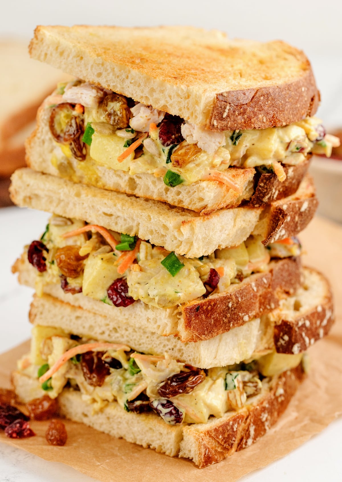 Curried turkey salad sandwiches are the perfect way to turn leftover turkey into something amazing. Packed with sweet, savory, and spiced flavors, these sandwiches make a standout meal. A triple stack of leftover curried turkey salad sandwiches