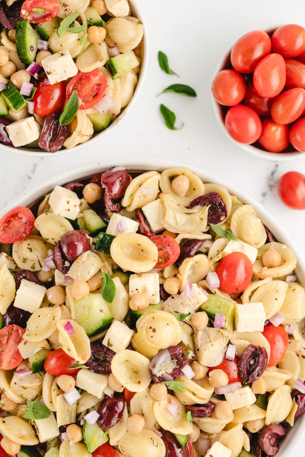 A portion of Greek pasta salad served on a plate with a fork, highlighting the colorful ingredients.