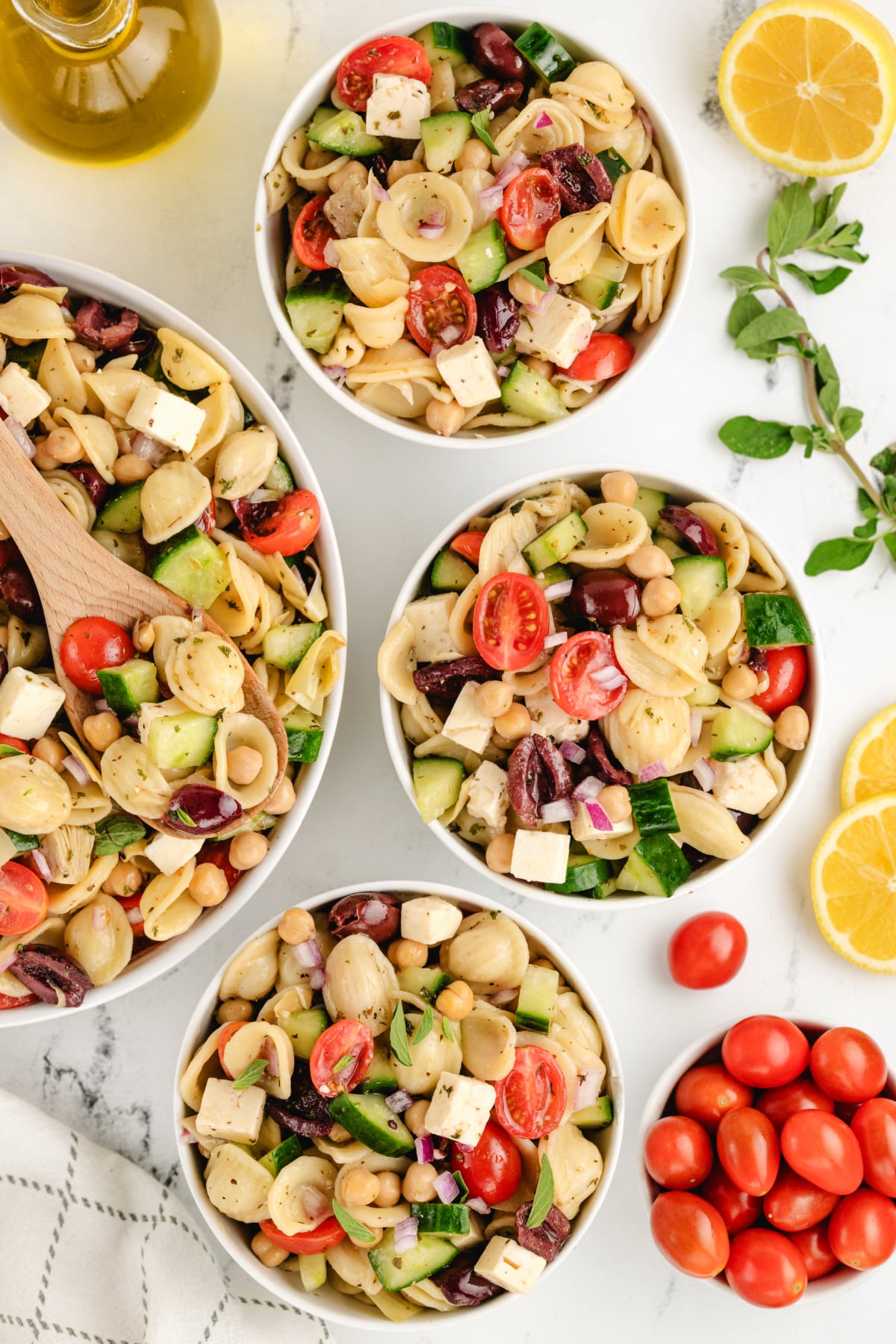 The pasta salad freshly tossed in a large bowl, with dressing evenly coating the pasta and toppings.