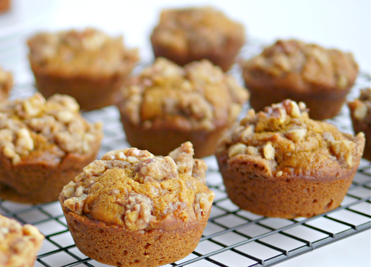 Batch of pumpkin brown sugar muffins cooling on a rack after baking.