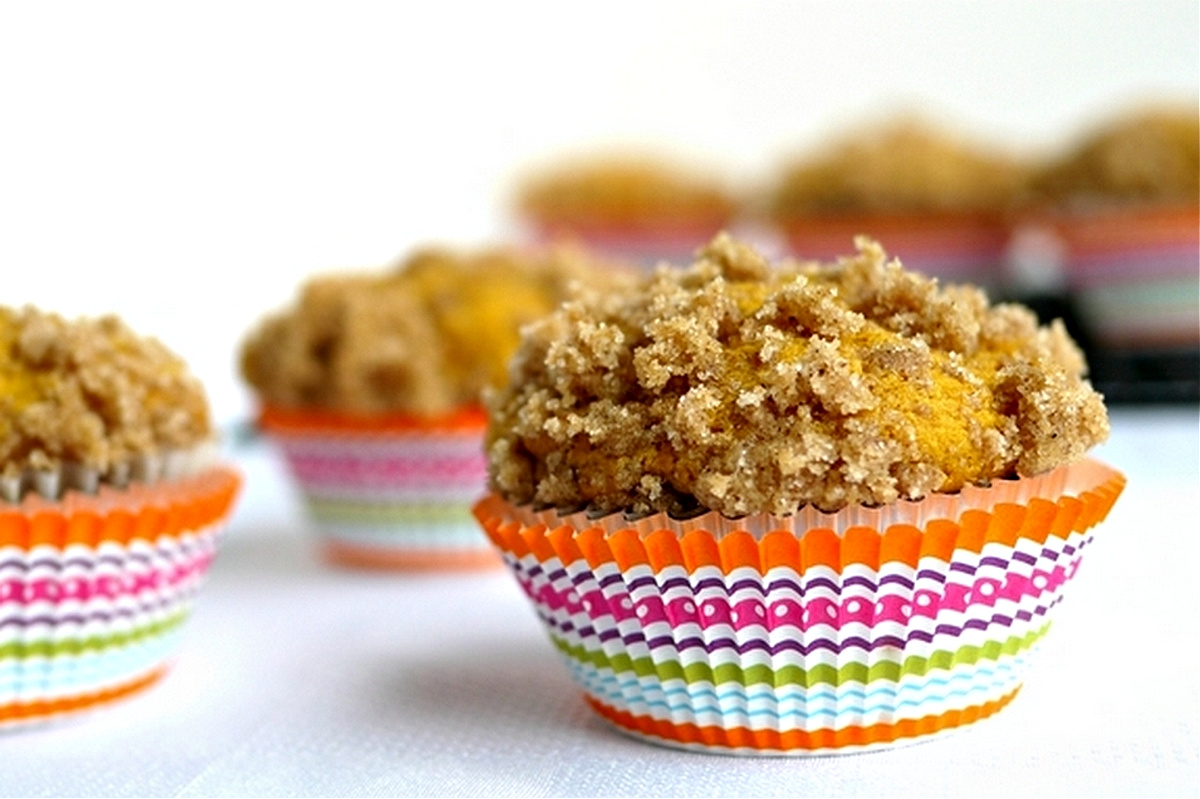 side view of buttermilk pumpkin muffins rising in pan with golden crumb topping