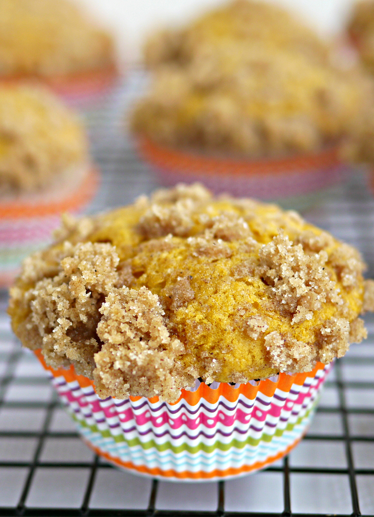 pumpkin muffins with buttermilk cooling on a wire rack in colorful liners