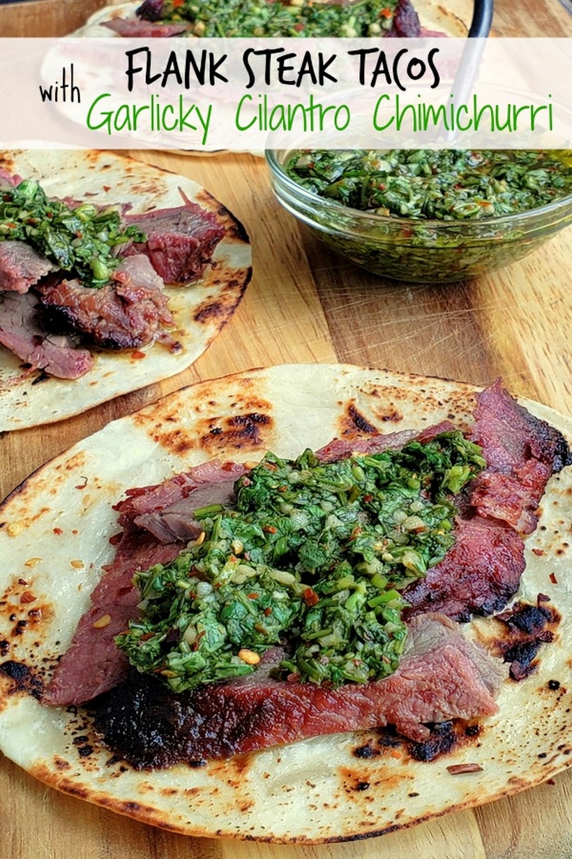 Make the best street food at home with these Flank Steak Tacos with Garlicky Cilantro Chimichurri. These tacos are essentially going to be your go-to summer, grilling meal. #noblepig #grilling #beef #flanksteak #chimichurri Text on photo reads Flank Steak Tacos with Garlicky Cilantro Chimichurri, with three tacos present and bowl of chimichurri.