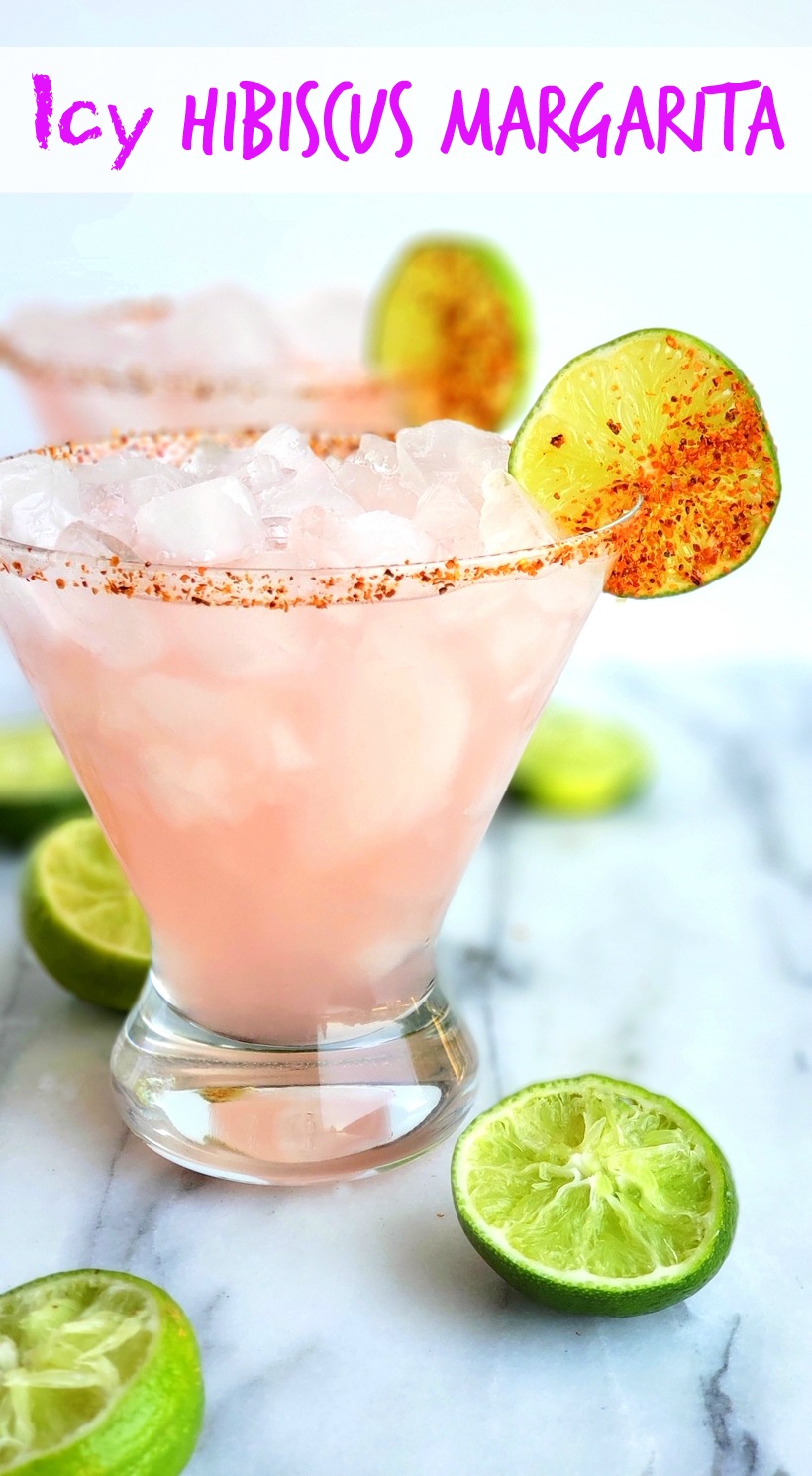 The petal pink color of this Icy Hibiscus Margarita is alluring, but it's the sweet, tangy and refreshing flavor that will have you asking for a second pour. #cocktail #noblepig Text reads icy hibiscus margarita with two margaritas in the photo.