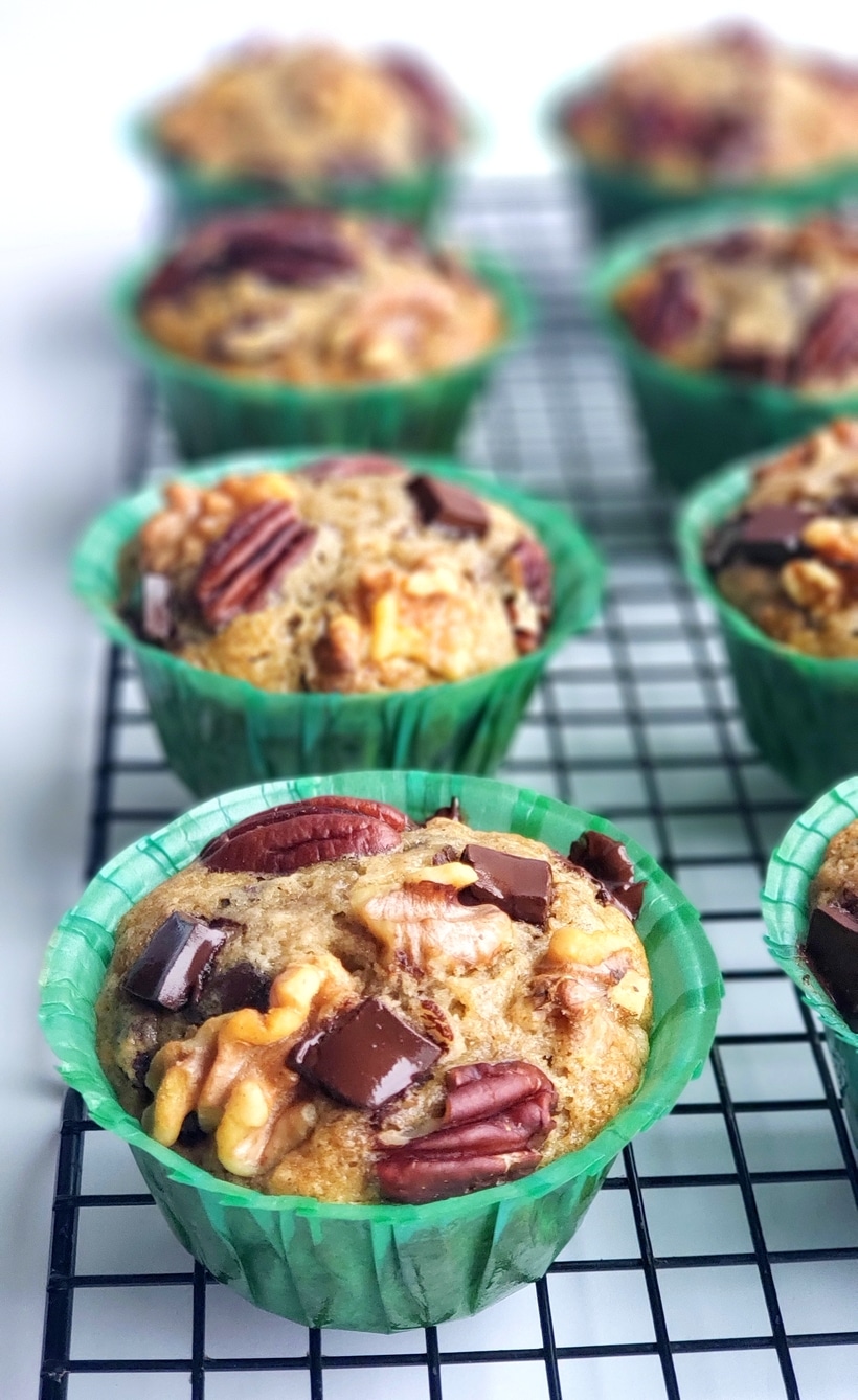 These Eggnog Banana Bread Muffins are tender, delicious and full of pure banana flavor. The eggnog lends a gentle nod to the holidays in a format that is perfect for celebrating Christmas brunch. This holiday breakfast muffin is the perfect cure to hunger while unwrapping those holiday gifts. #noblepig #eggnog #eggnogmuffins #eggnogbananamuffins #holidaybreakfastrecipes #holidaybreakfastideas #christmasbrunch #holidaymuffinrecipe #fluffyeggnogmuffins #christmasbreakfast #muffins #muffinrecipe Eggnog Muffins on a cooling tray.
