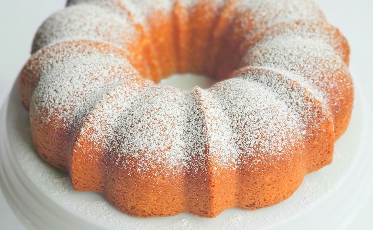 RumChata Bundt Cake on a cake stand. RumChata Cake dusted with powdered sugar.
