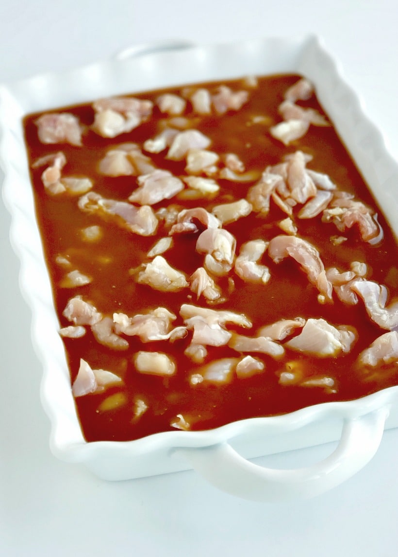 Chicken marinating in a serving platter.