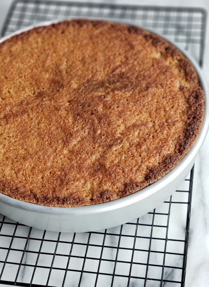 Baked cake on a cooling rack still in the baking pan.