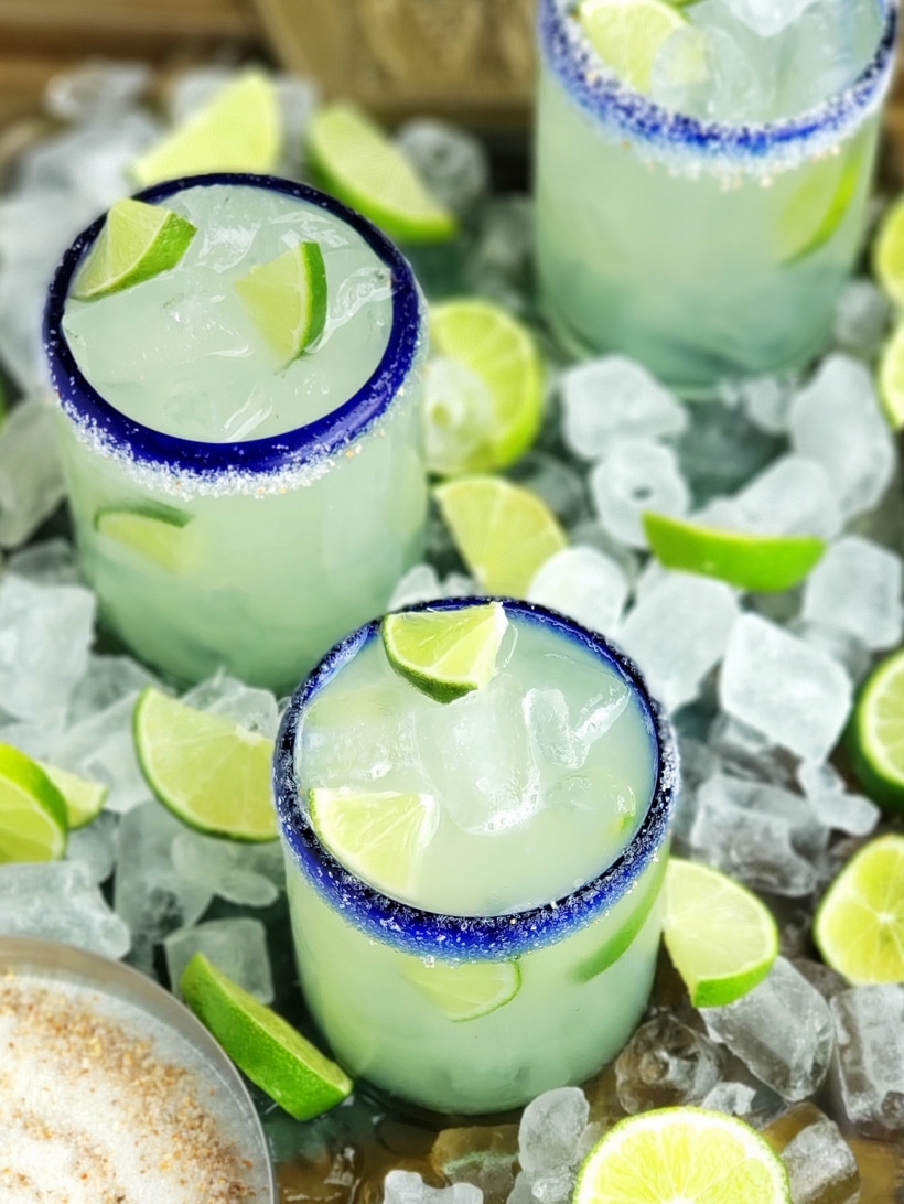 Three ingredients is all you need to make this outstanding margarita with agave as its sweetener. Perfectly balanced and refreshing, this agave margarita recipe will be your new favorite patio drink. Overhead of agave margaritas in glasses.
