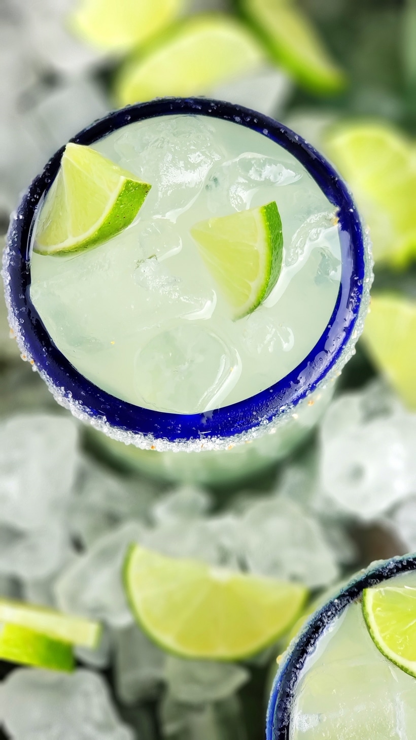 Three ingredients is all you need to make this outstanding margarita with agave as its sweetener. Perfectly balanced and refreshing, this agave margarita recipe will be your new favorite patio drink. Overhead view of agave margaritas in glasses.