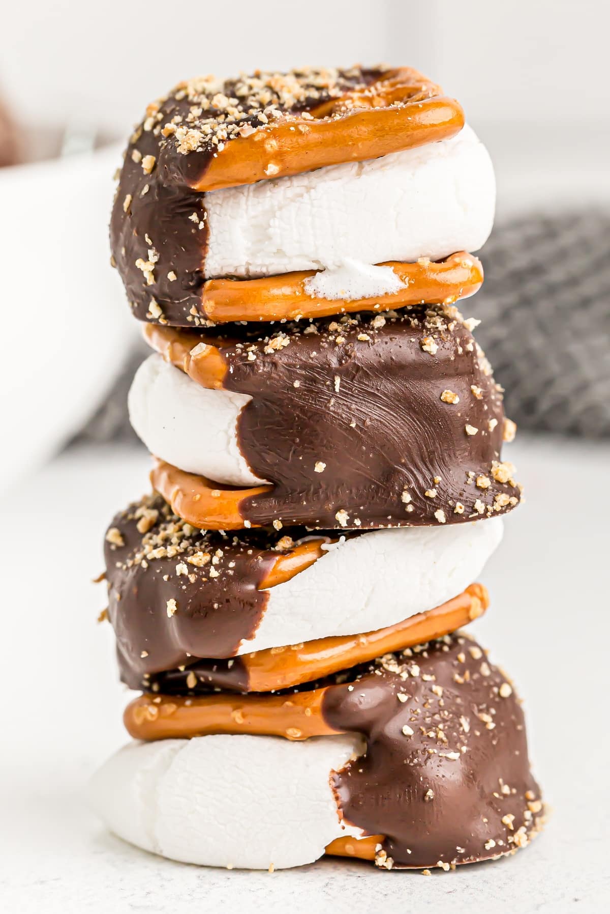 stacked pretzel s’mores with chocolate and marshmallow filling Stack of four gooey s’mores pretzels showing marshmallow layers and chocolate-dipped sides