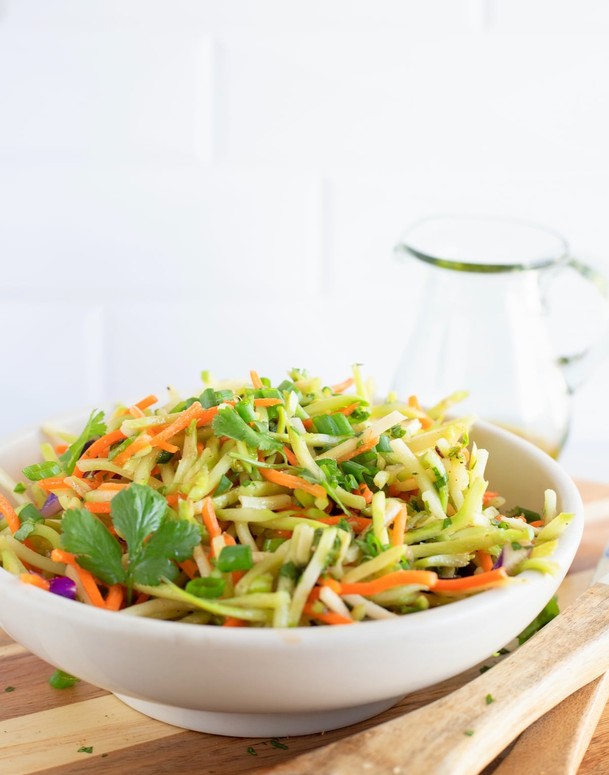 Bowl of freshly prepared cilantro lime broccoli slaw with vibrant green color and tangy dressing.
