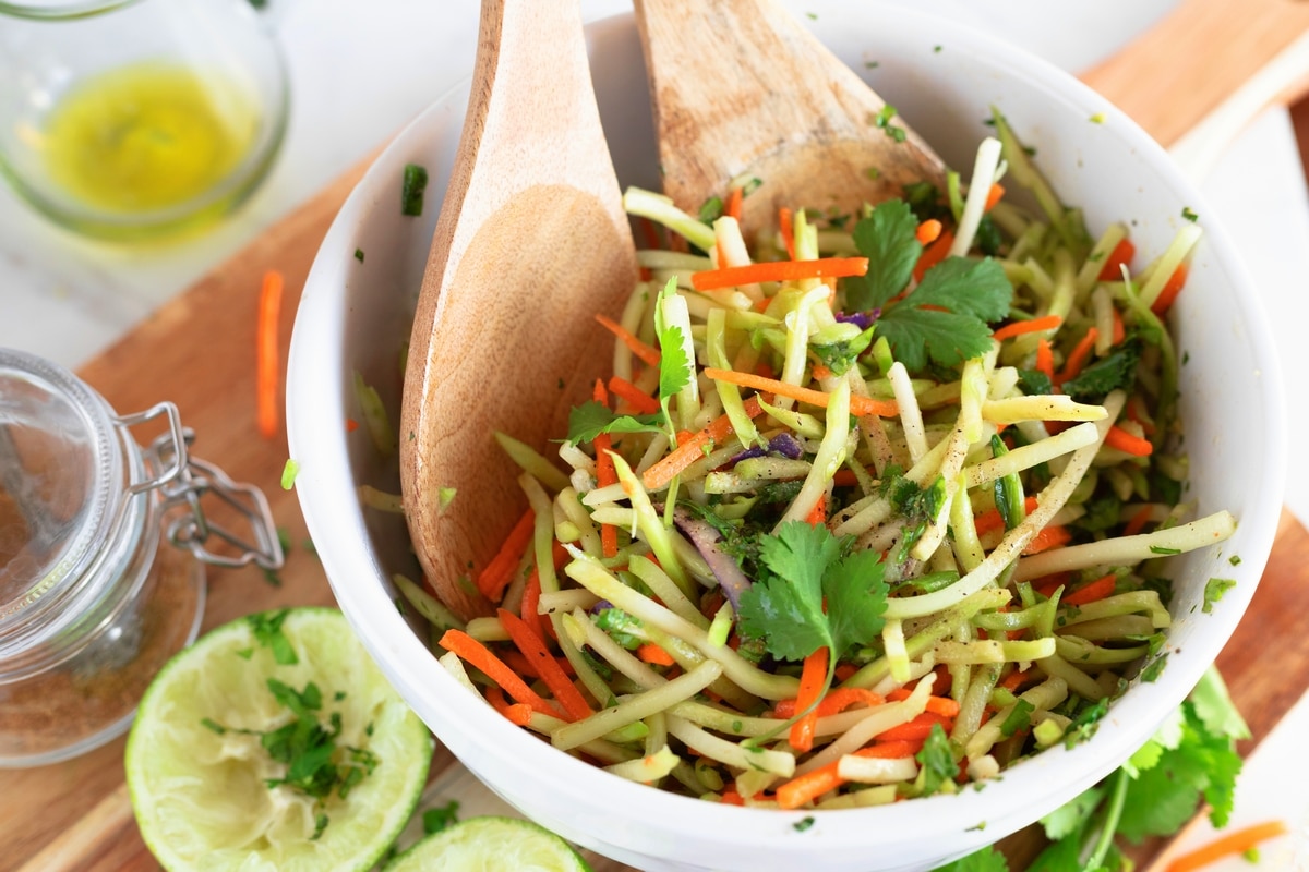 Bowl of freshly prepared cilantro lime broccoli slaw with vibrant green color and tangy dressing.