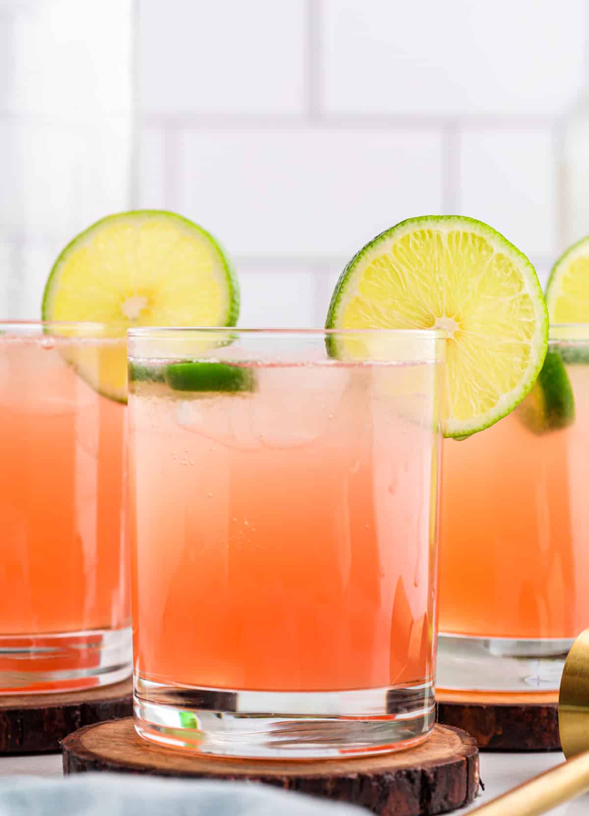 Straight-on view of spicy watermelon margarita with lime wheel and jalapeño slices