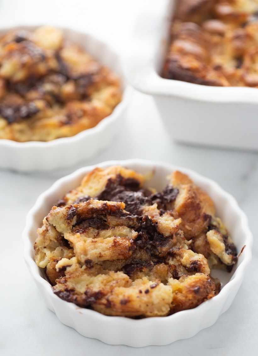 Chocolate Croissant Bread Pudding servings Three small dishes of chocolate croissant bread pudding, each showing a warm, custardy interior with bits of melted chocolate.