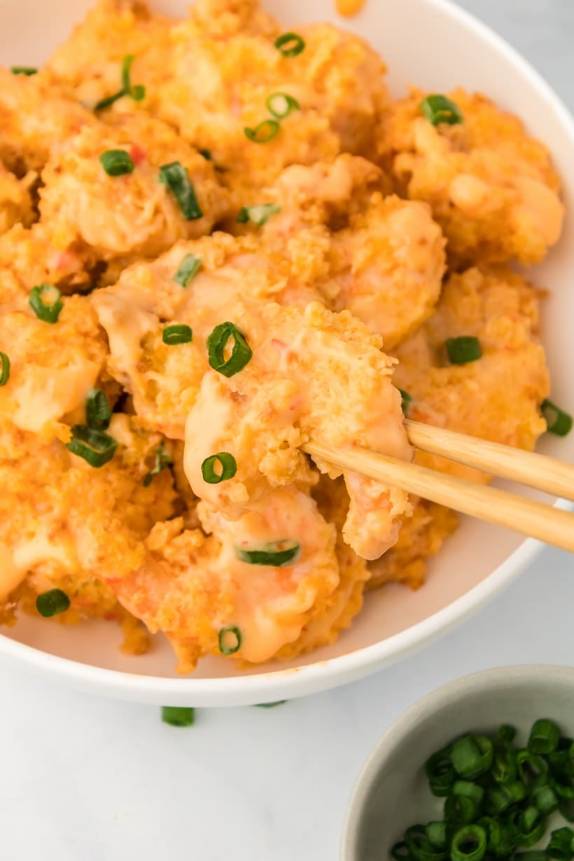 finished bang bang shrimp made in air fryer Crunchy air fryer shrimp with sweet and spicy sauce in white bowl