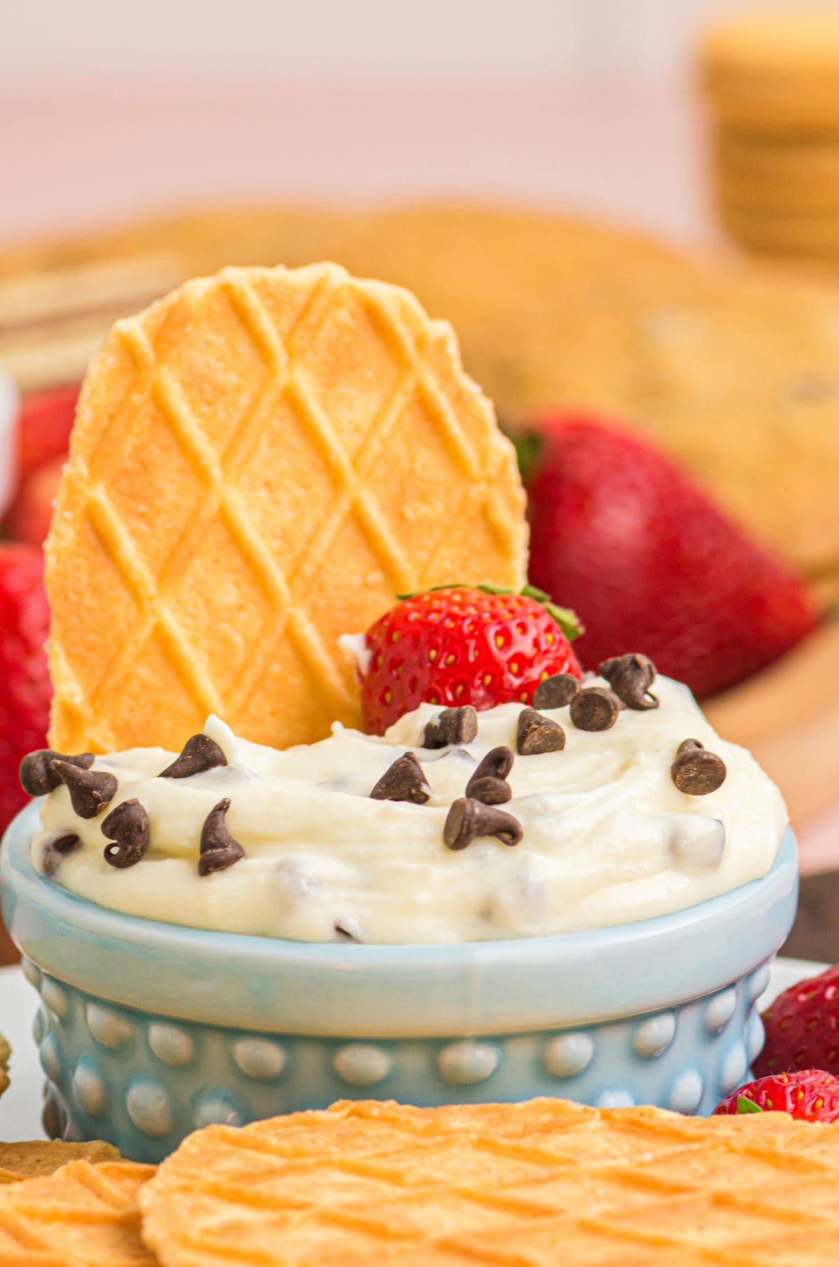 Cannoli dip in blue bowl with waffle cone Cannoli dip in a blue bowl with a whole waffle cone and strawberry