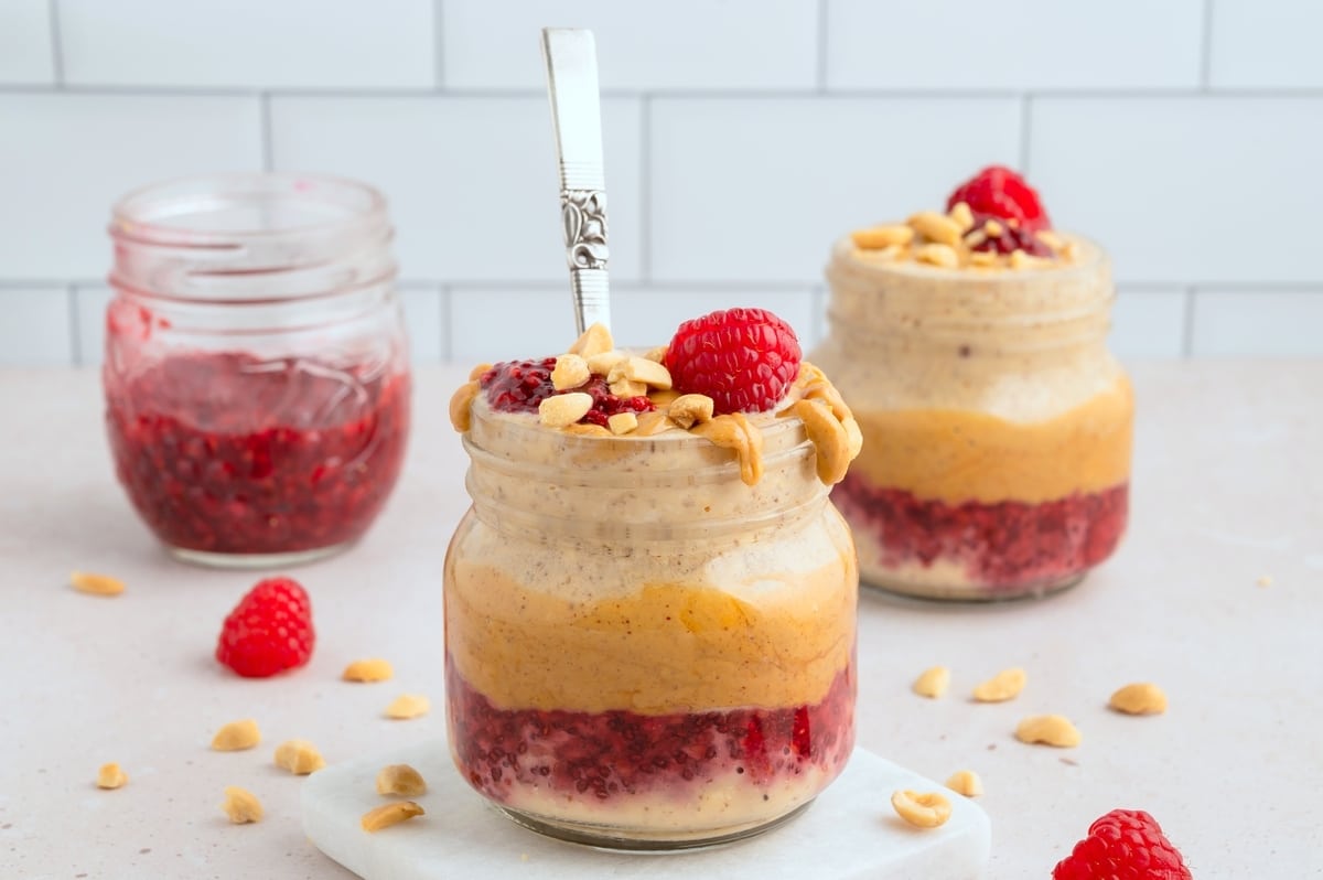Close-up of creamy Peanut Butter and Jelly Overnight Oats with fresh berries and crushed peanuts.