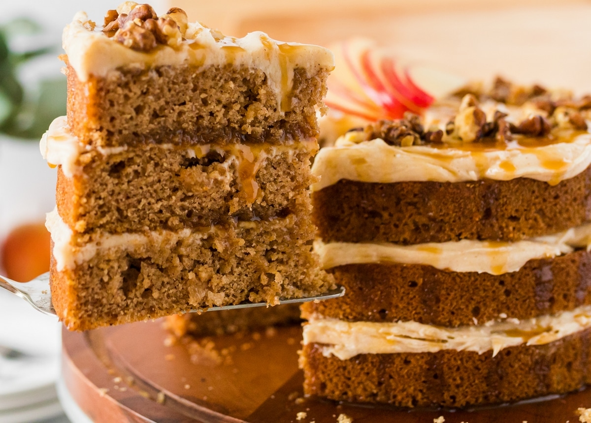 Pulling a Slice from Caramel Apple Cake Close-up of a slice being pulled from a caramel apple layer cake, showcasing its moist layers and frosting.
