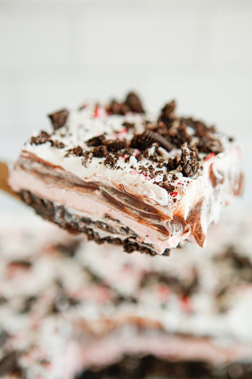 Slice of Chocolate Peppermint Lush on Spatula Close-up of a slice of Chocolate Peppermint Lush on a spatula, showcasing its creamy layers and festive look.