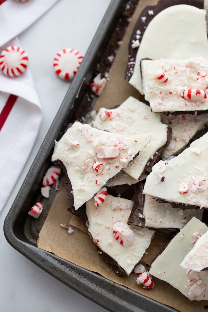 Broken pieces of double chocolate peppermint bark scattered on a baking tray.
